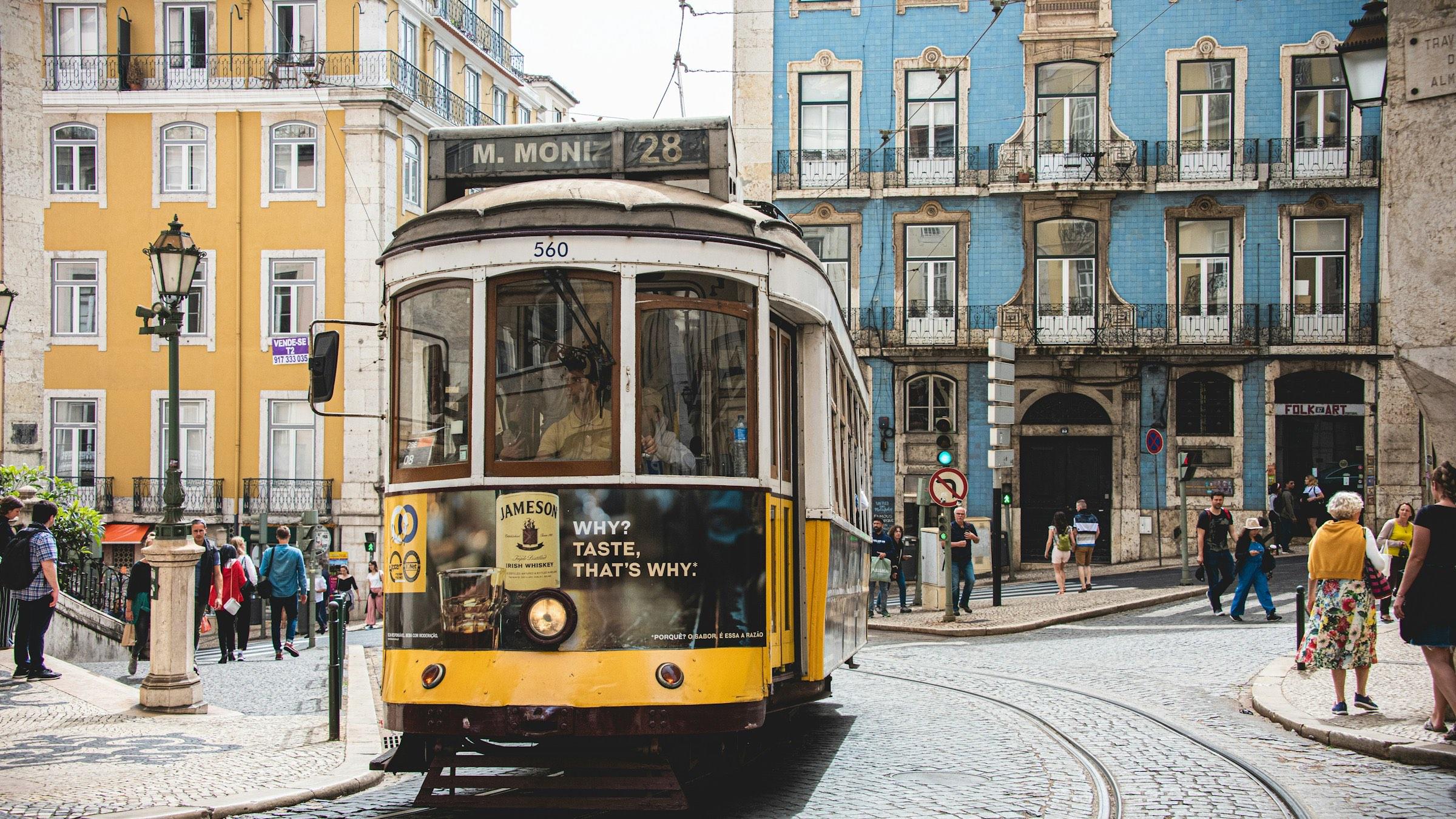 A yellow tram on a street in Lisbon