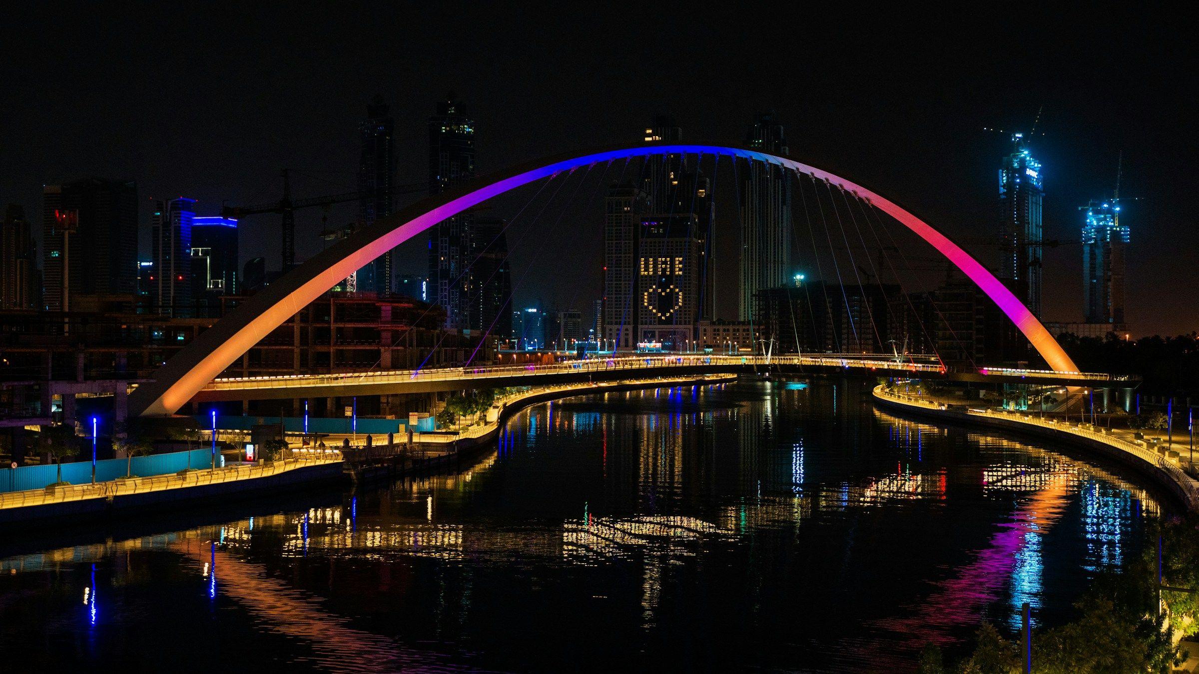 The Tolerance Bridge over the Dubai Water Canal, lit up at night