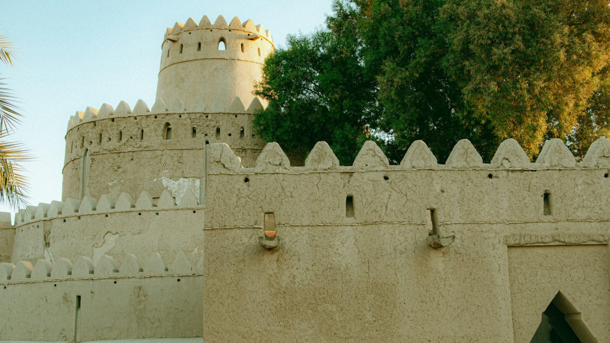 The crenellated walls and round tower of Al Jahili Fort in Al Ain