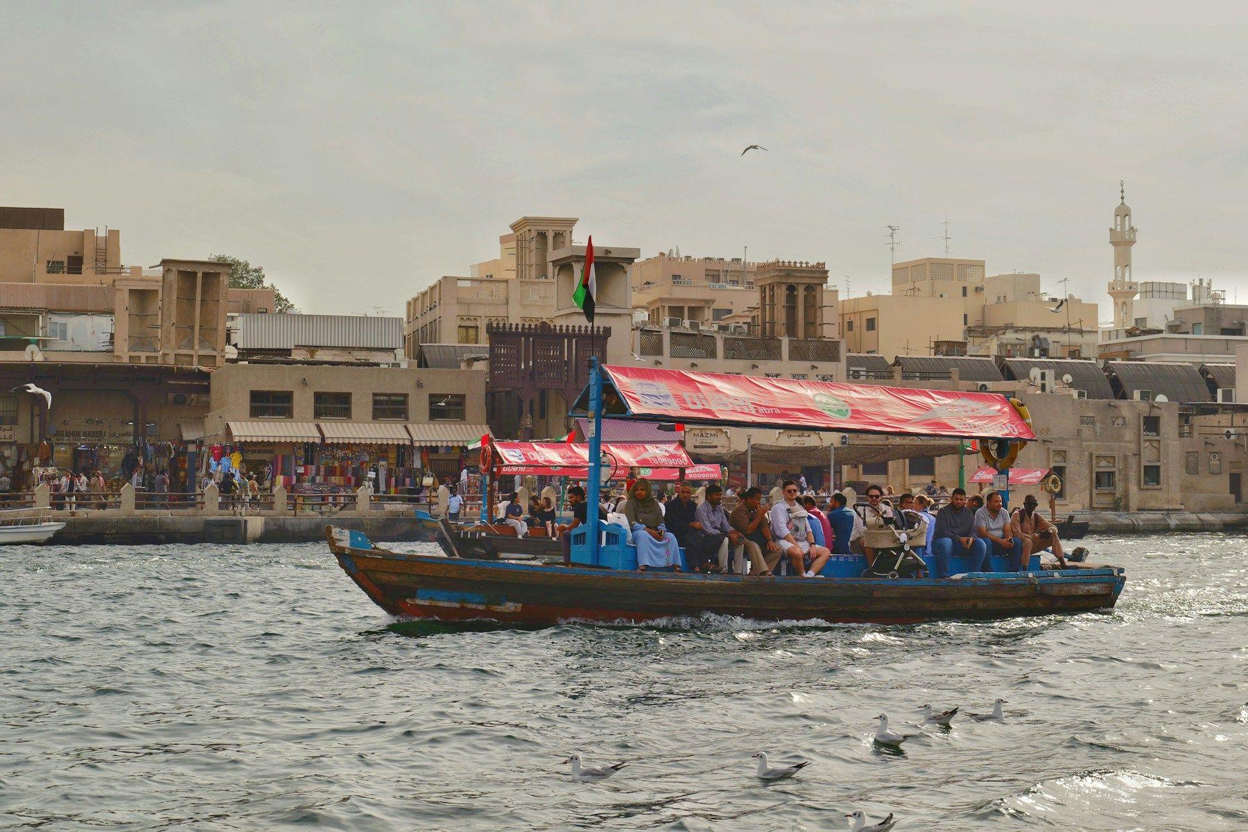 An abra water taxi full of passengers crossing Dubai Creek