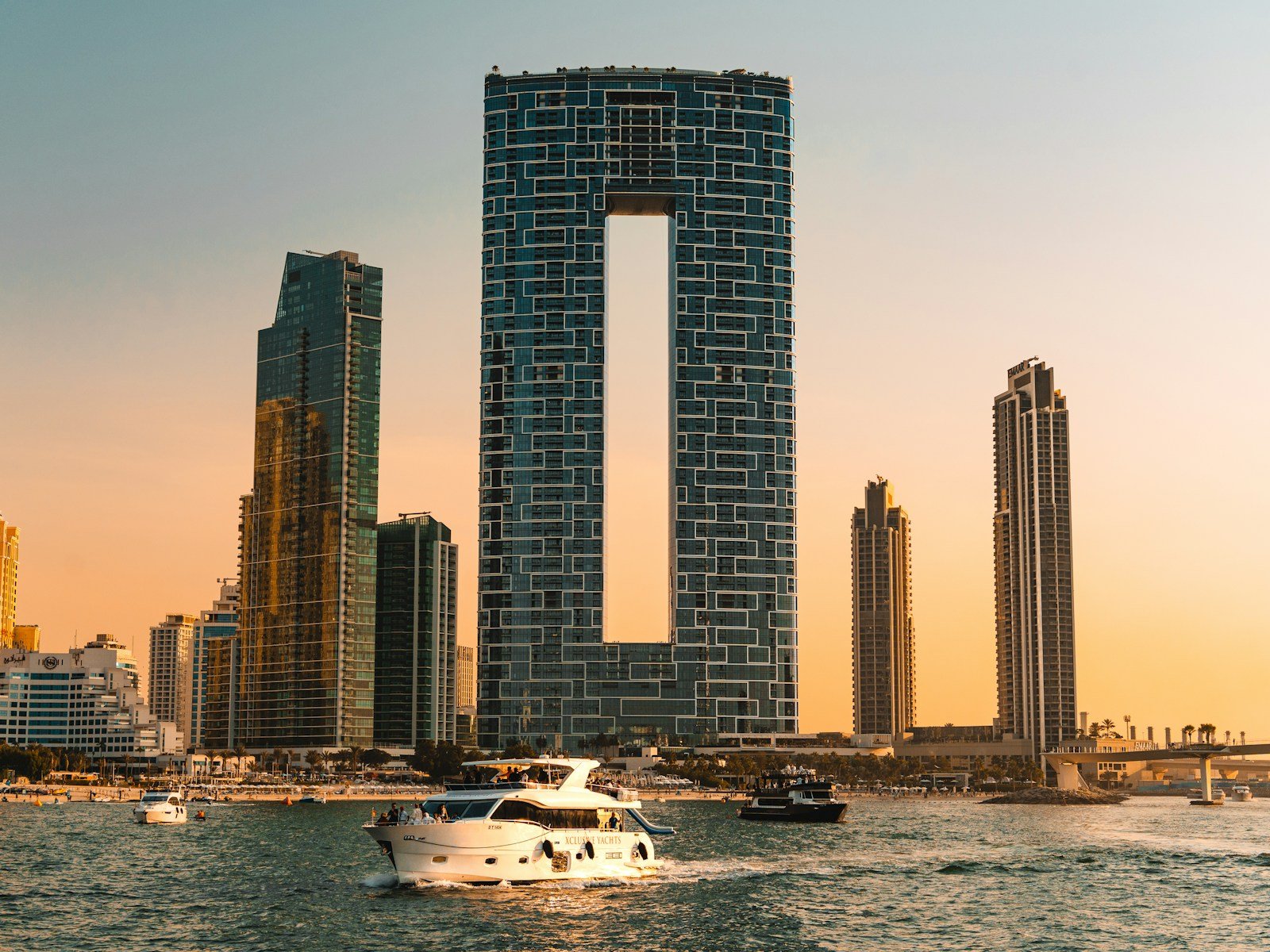 A yacht passing the towers of JBR and Dubai Marina at sunset
