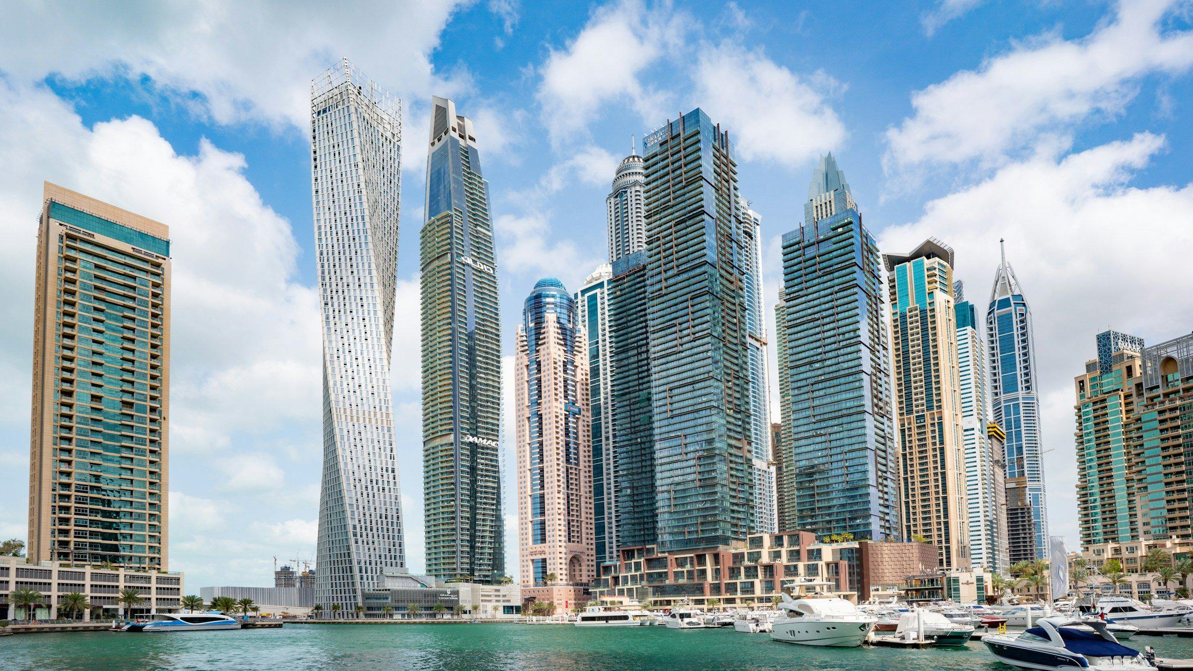 Dubai Marina's towers, including the twisting Cayan Tower, above boats in the marina