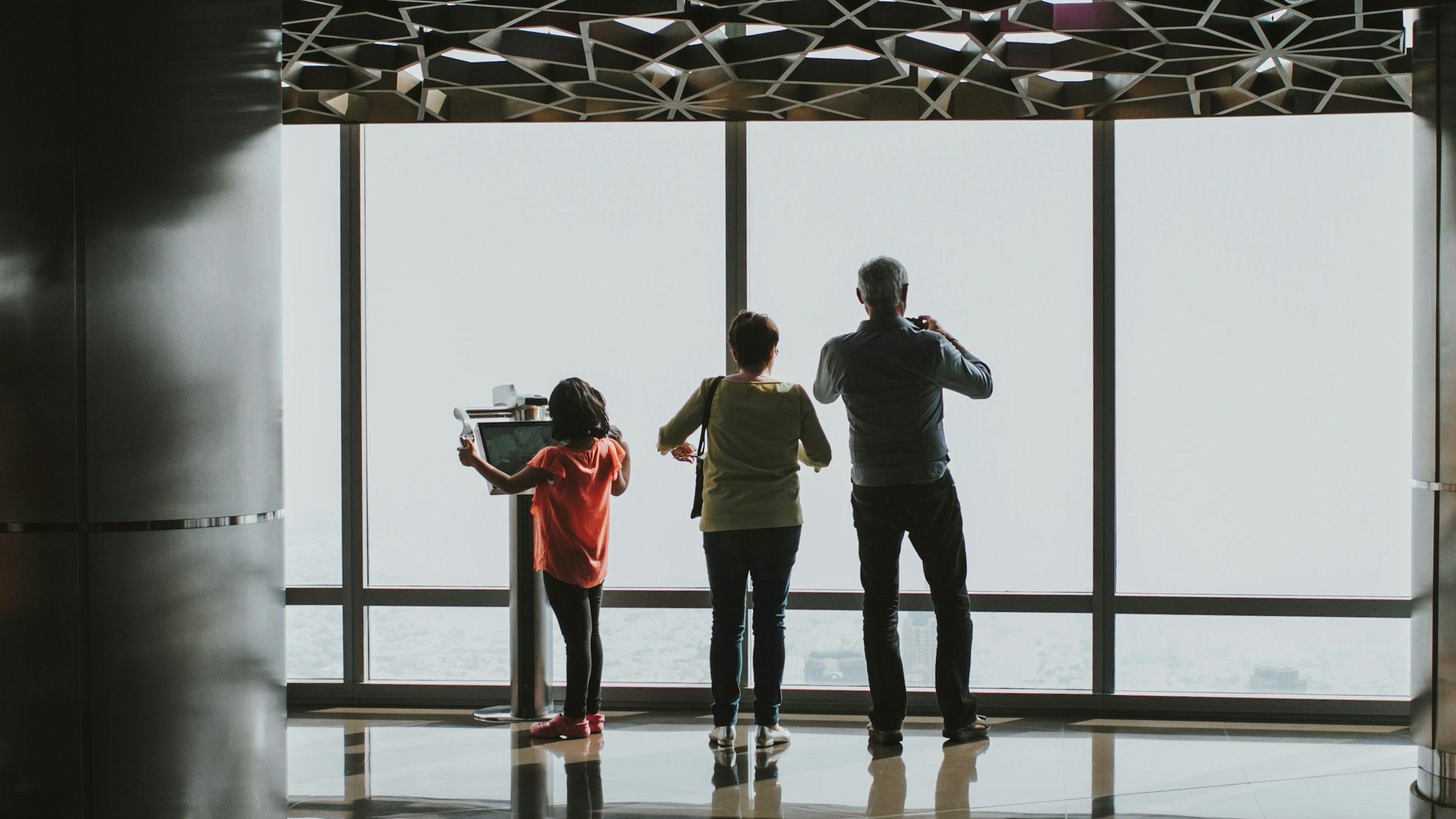 A family at the observation deck windows of the Burj Khalifa, Dubai