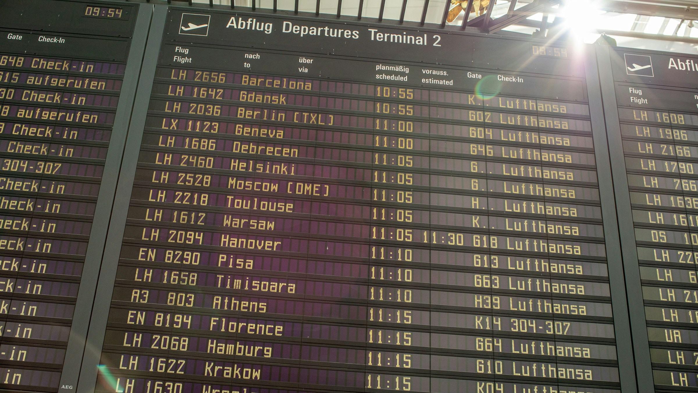 A departures board listing flights to European cities at an airport terminal