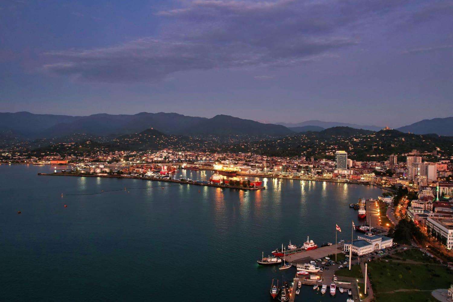 Batumi harbour and the seafront lit up at dusk