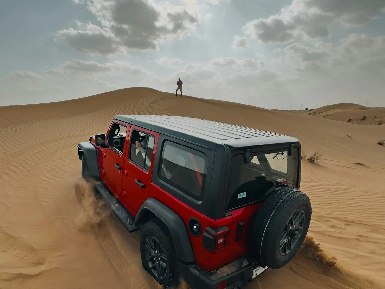 A red 4x4 on a dune on a Dubai desert safari