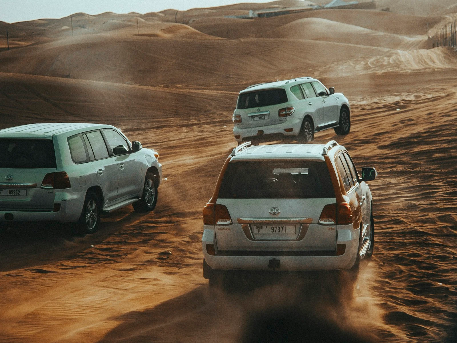 سيارات 4x4 تسير في موكب عبر صحراء دبي
