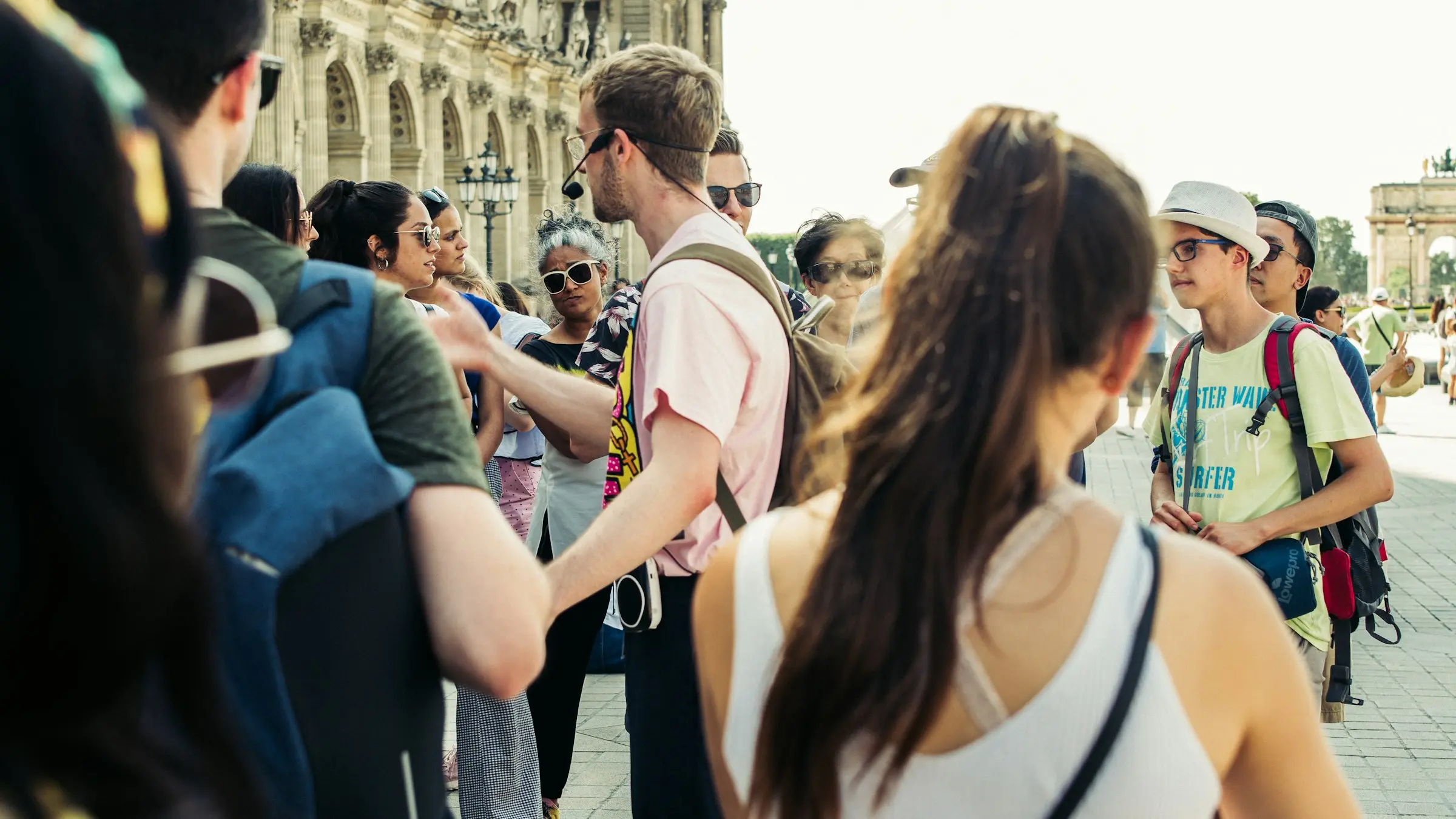 A guide briefing a tour group outside the Louvre in Paris