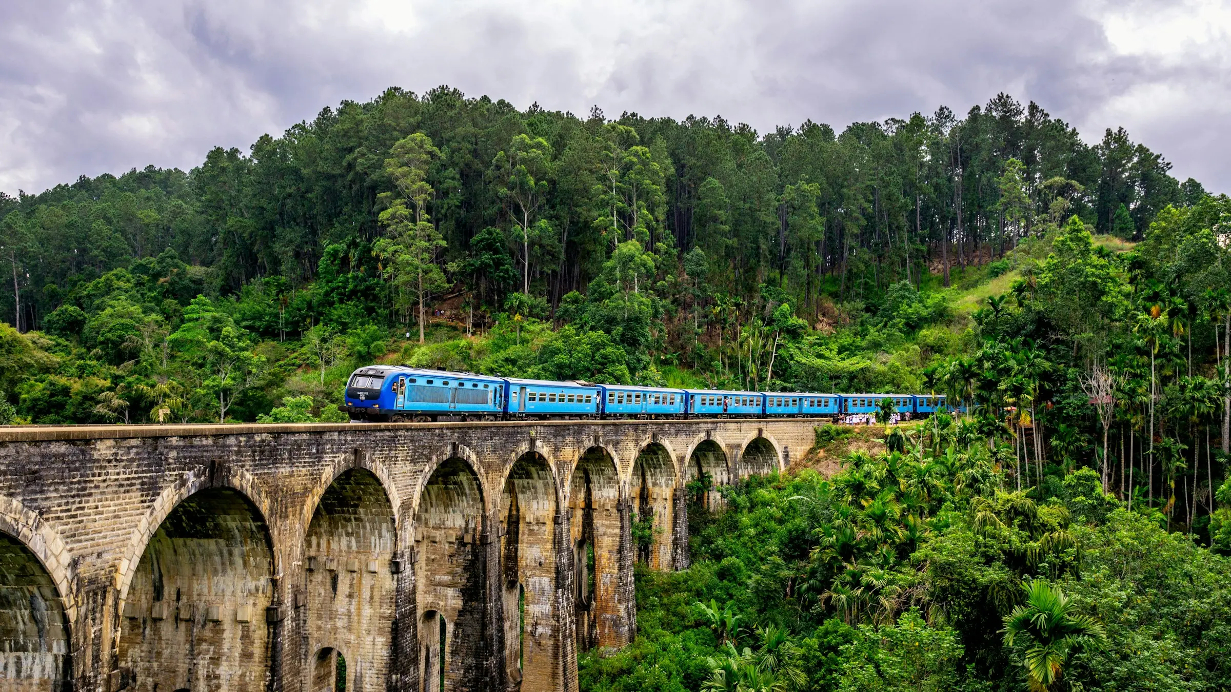 A blue train crossing the Nine Arches Bridge near Ella, in Sri Lanka's hill country