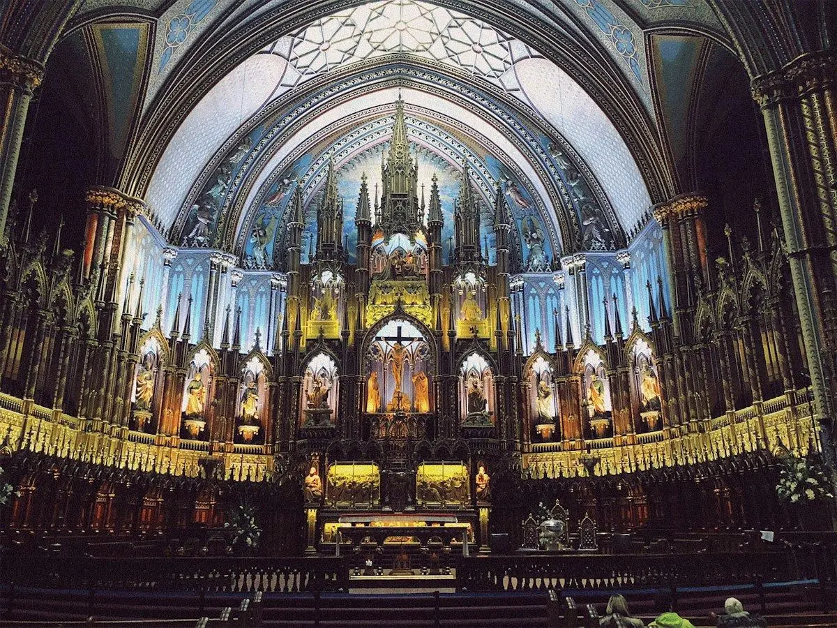 The blue-lit altar and vaulted ceiling of Notre-Dame Basilica in Montreal
