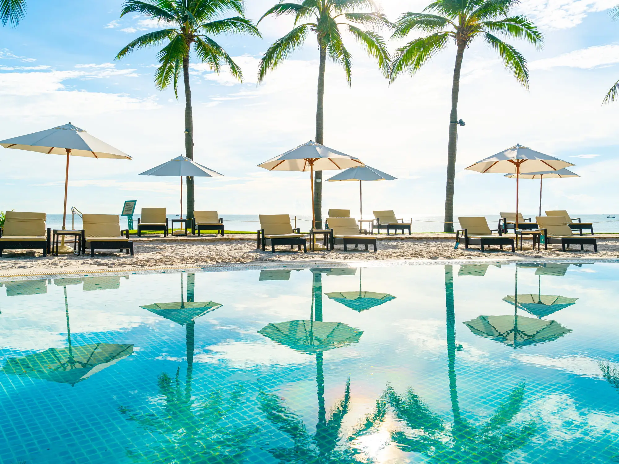 A resort pool lined with palm trees in Bali