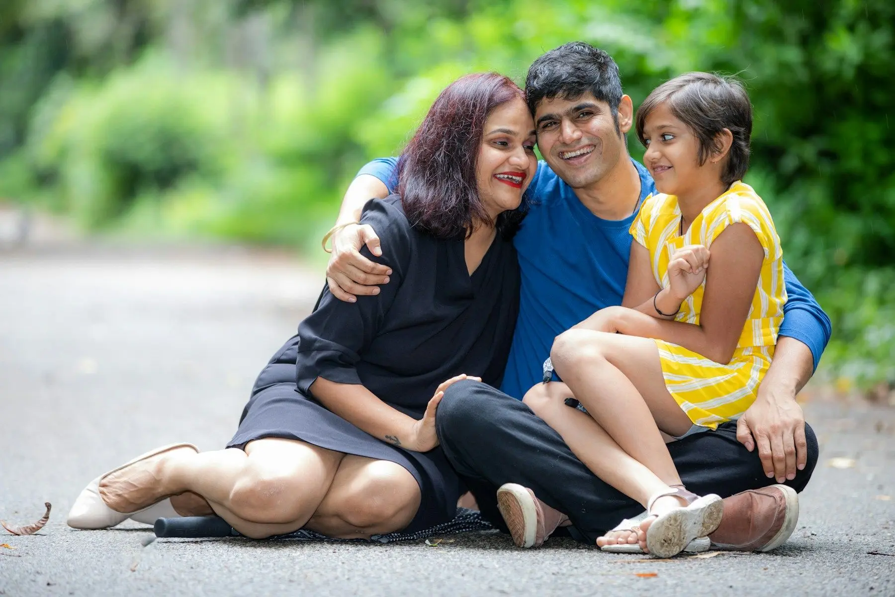 A mother, father and young daughter sitting together and smiling