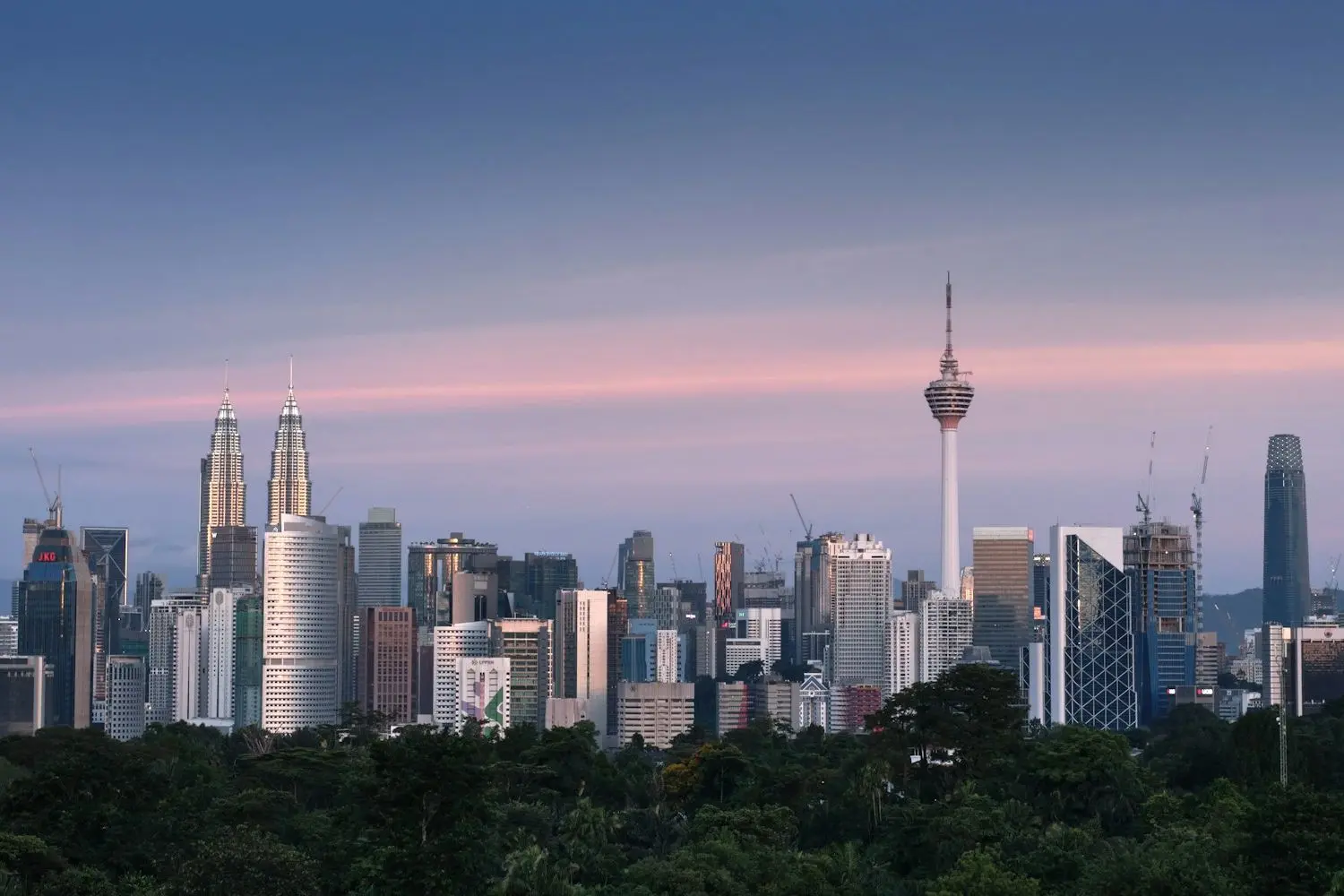 The Kuala Lumpur skyline at dusk, with the Petronas Towers and KL Tower