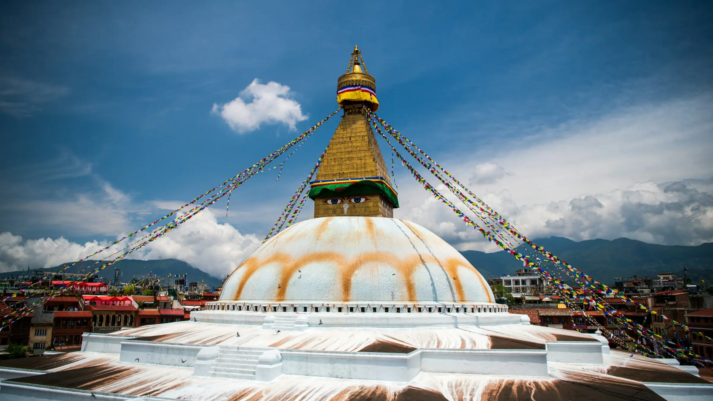 Prayer flags strung from the white dome of Boudhanath Stupa in Kathmandu