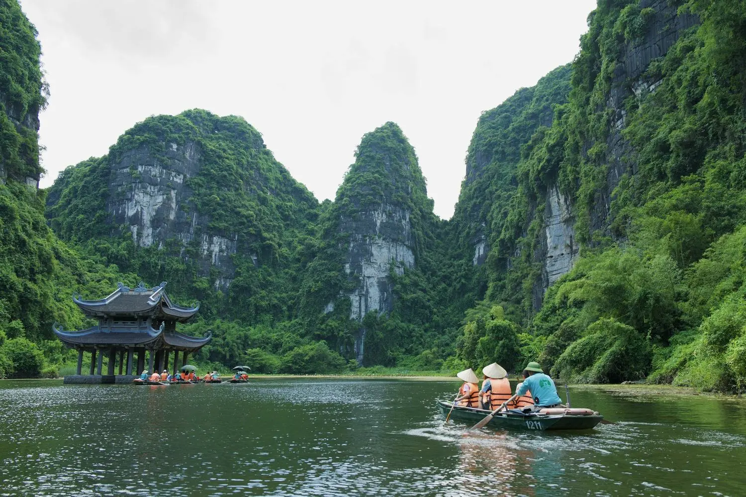 A rowing boat on the river among the limestone peaks of Trang An, Ninh Binh