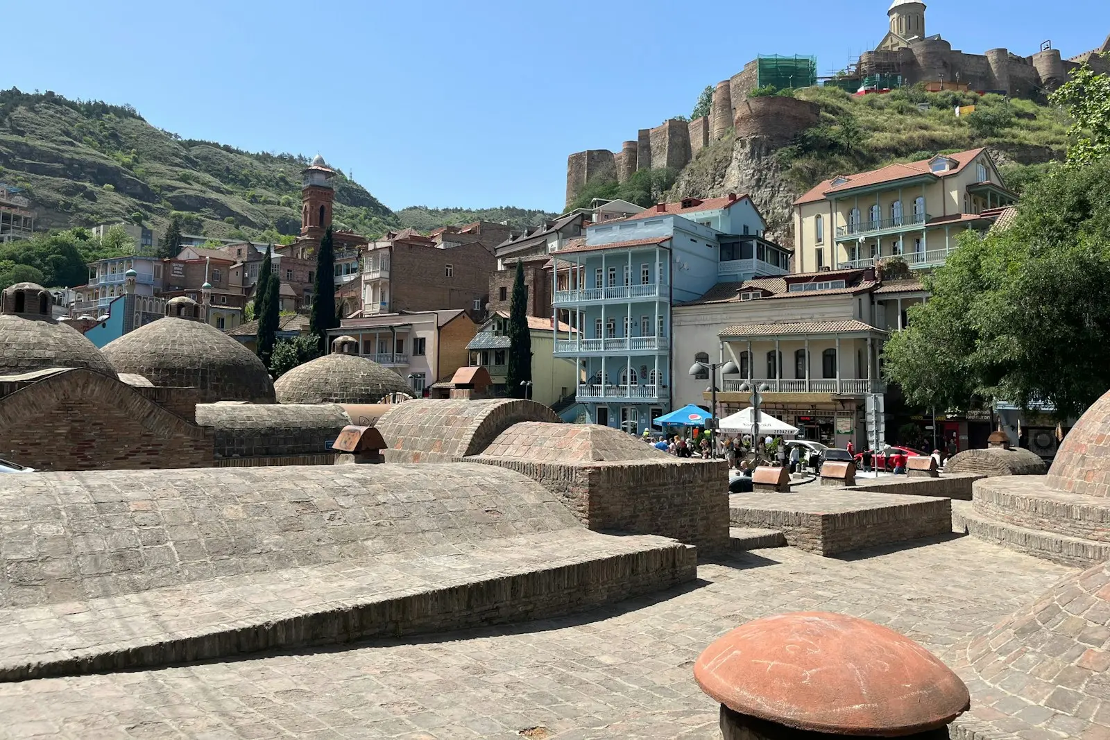 The brick domes of the Abanotubani sulphur baths in Tbilisi, with Narikala Fortress on the hill above