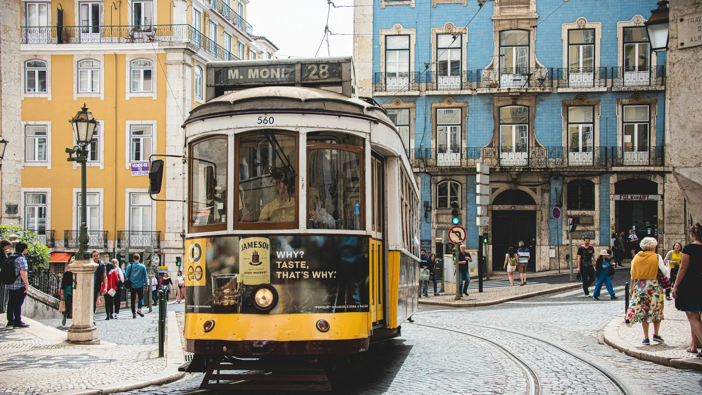A yellow tram on a street in Lisbon