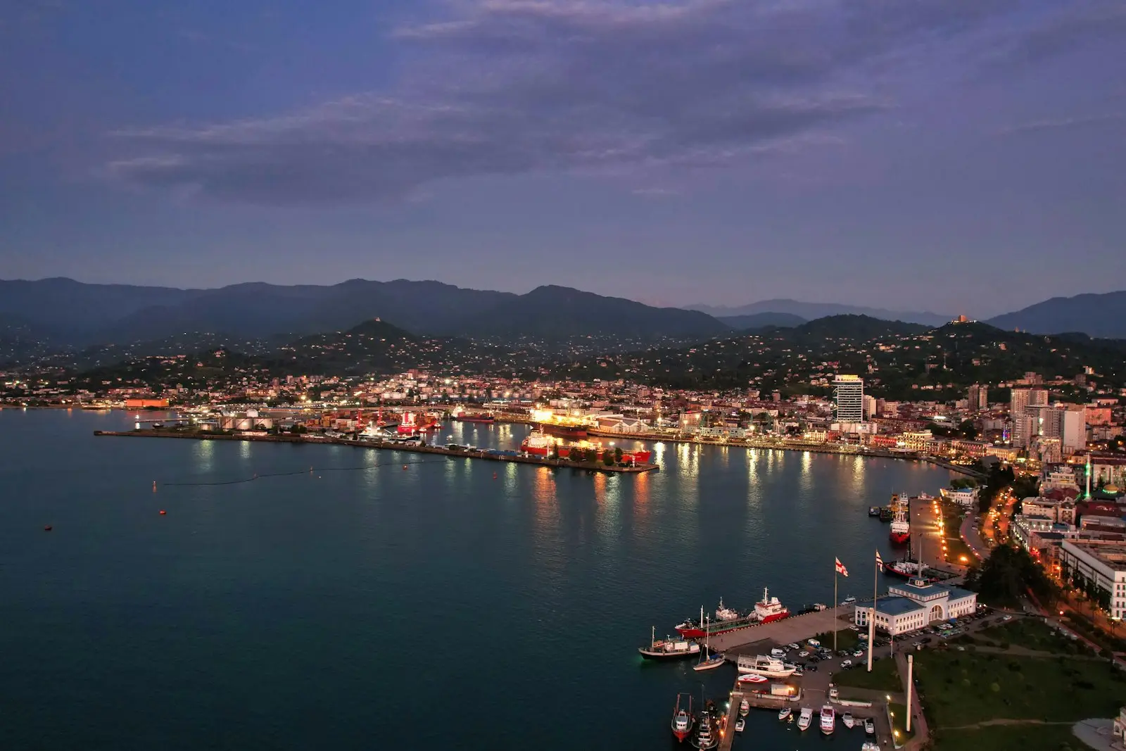 Batumi harbour and the seafront lit up at dusk