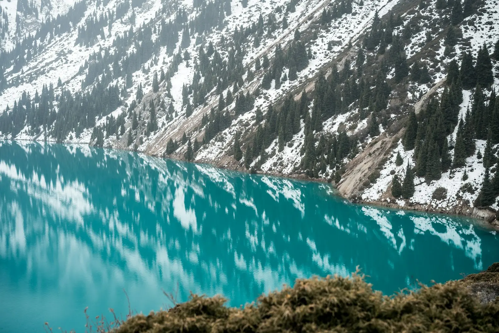 The turquoise Big Almaty Lake below snow-dusted mountains