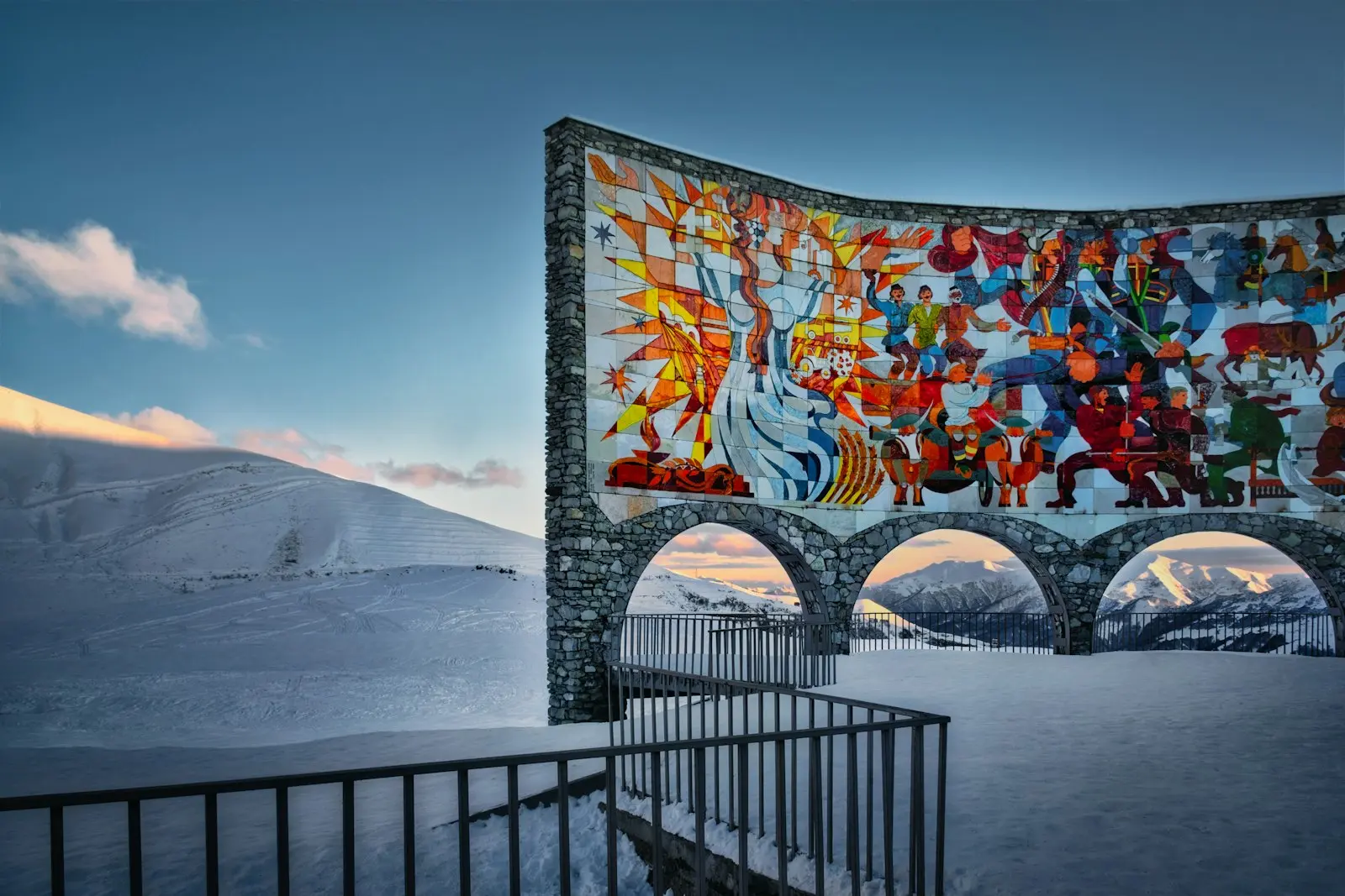 The mosaic arch of the Friendship Monument above the snow at Gudauri