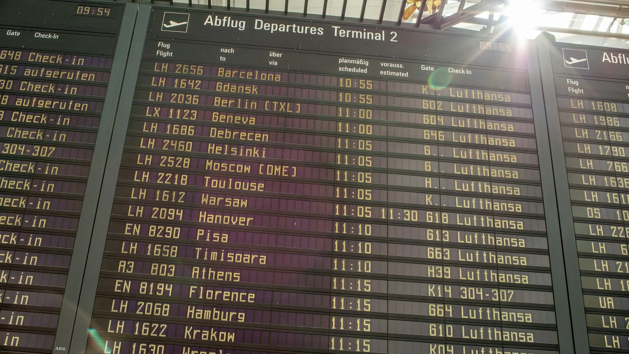A departures board listing flights to European cities at an airport terminal