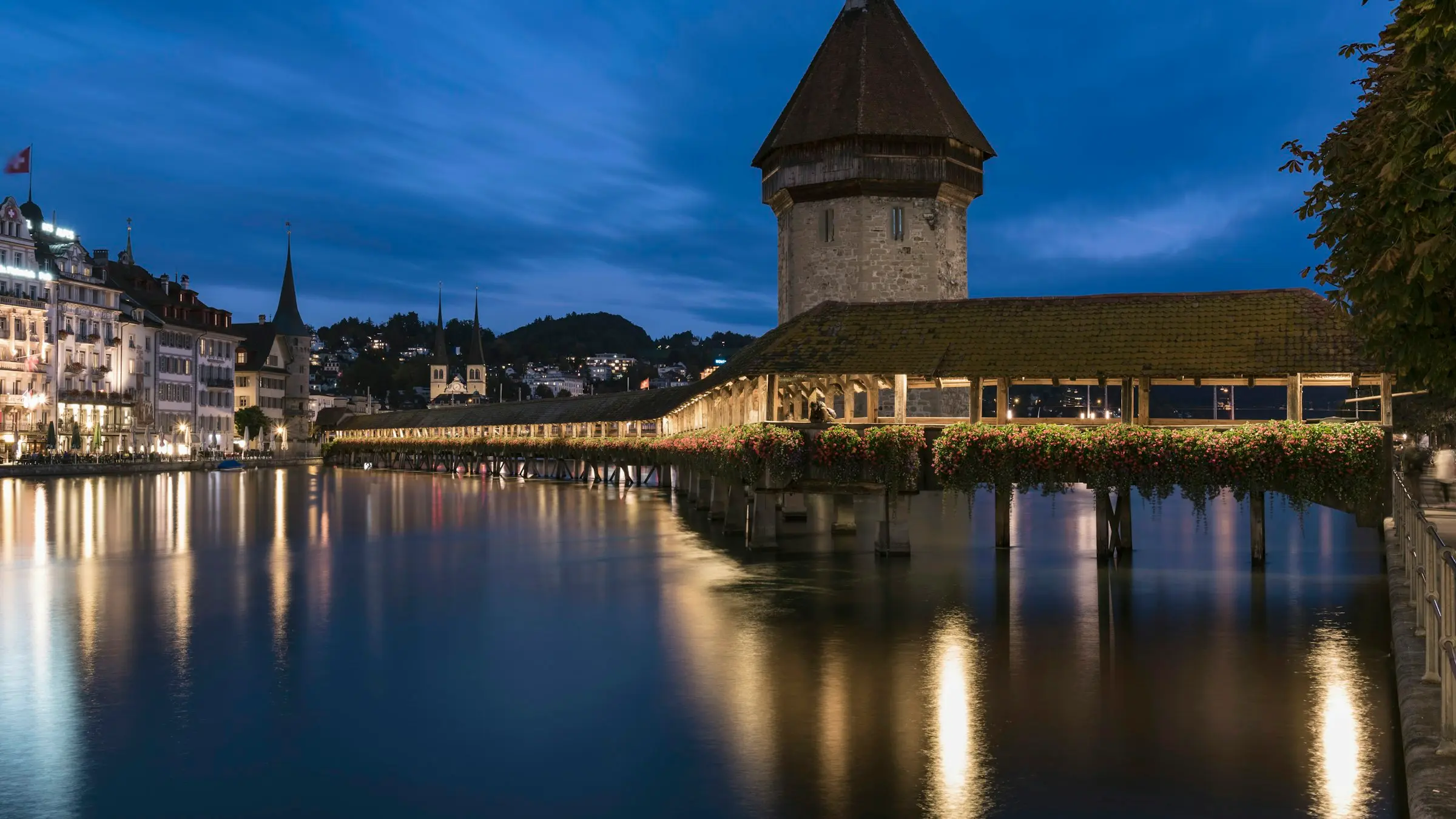 Lucerne's Chapel Bridge and Water Tower lit up on the Reuss at dusk, Switzerland