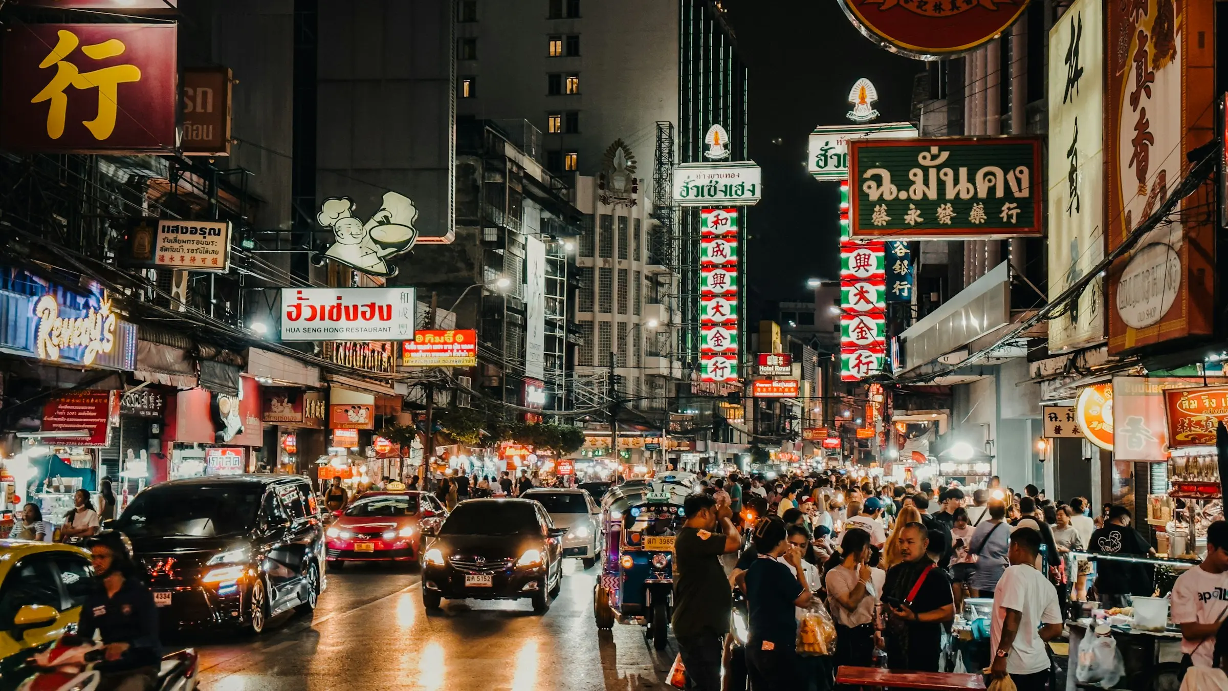 Neon shop signs above the evening crowds and street food stalls on Yaowarat Road, Bangkok