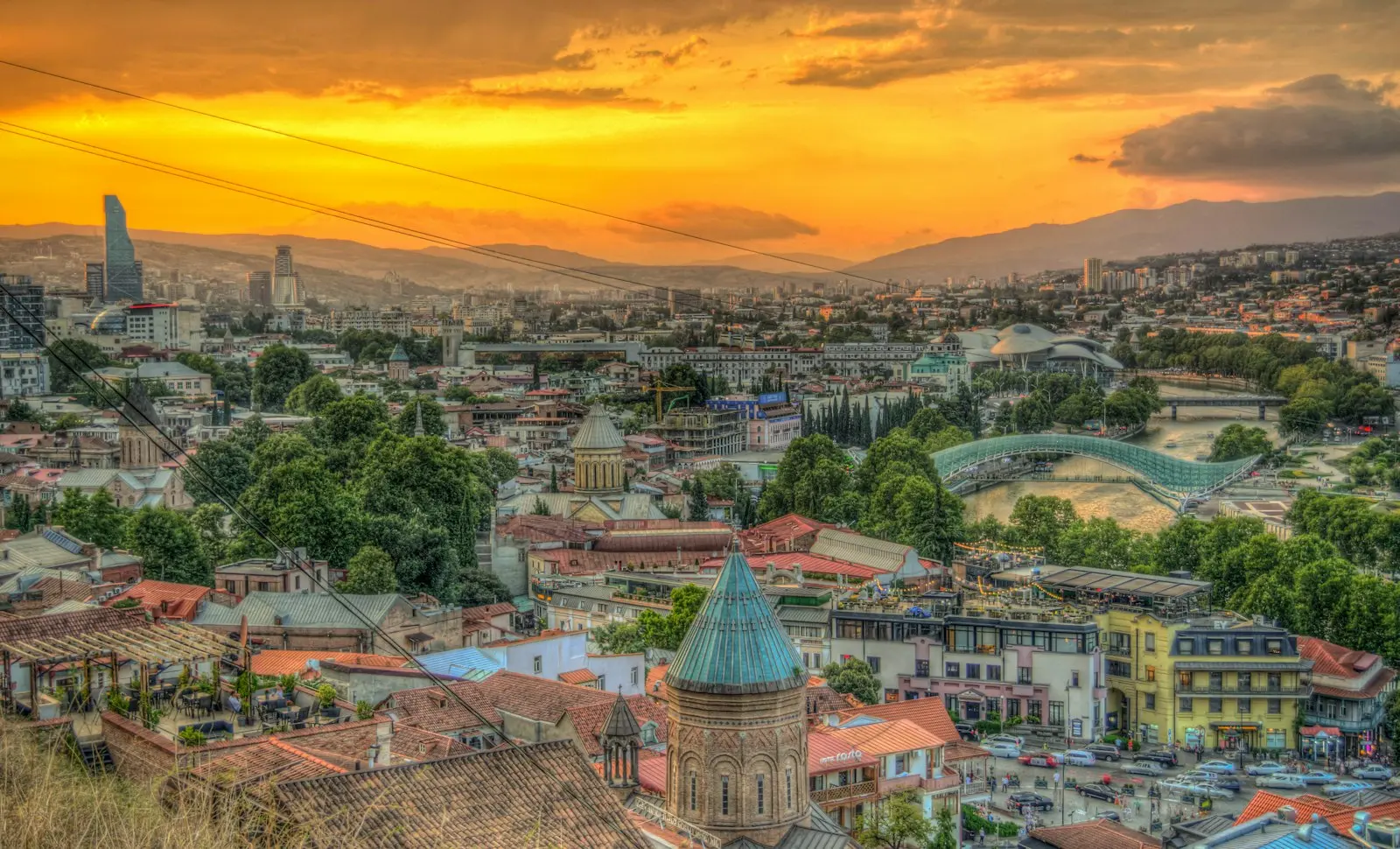 The rooftops of Tbilisi under an orange sunset sky