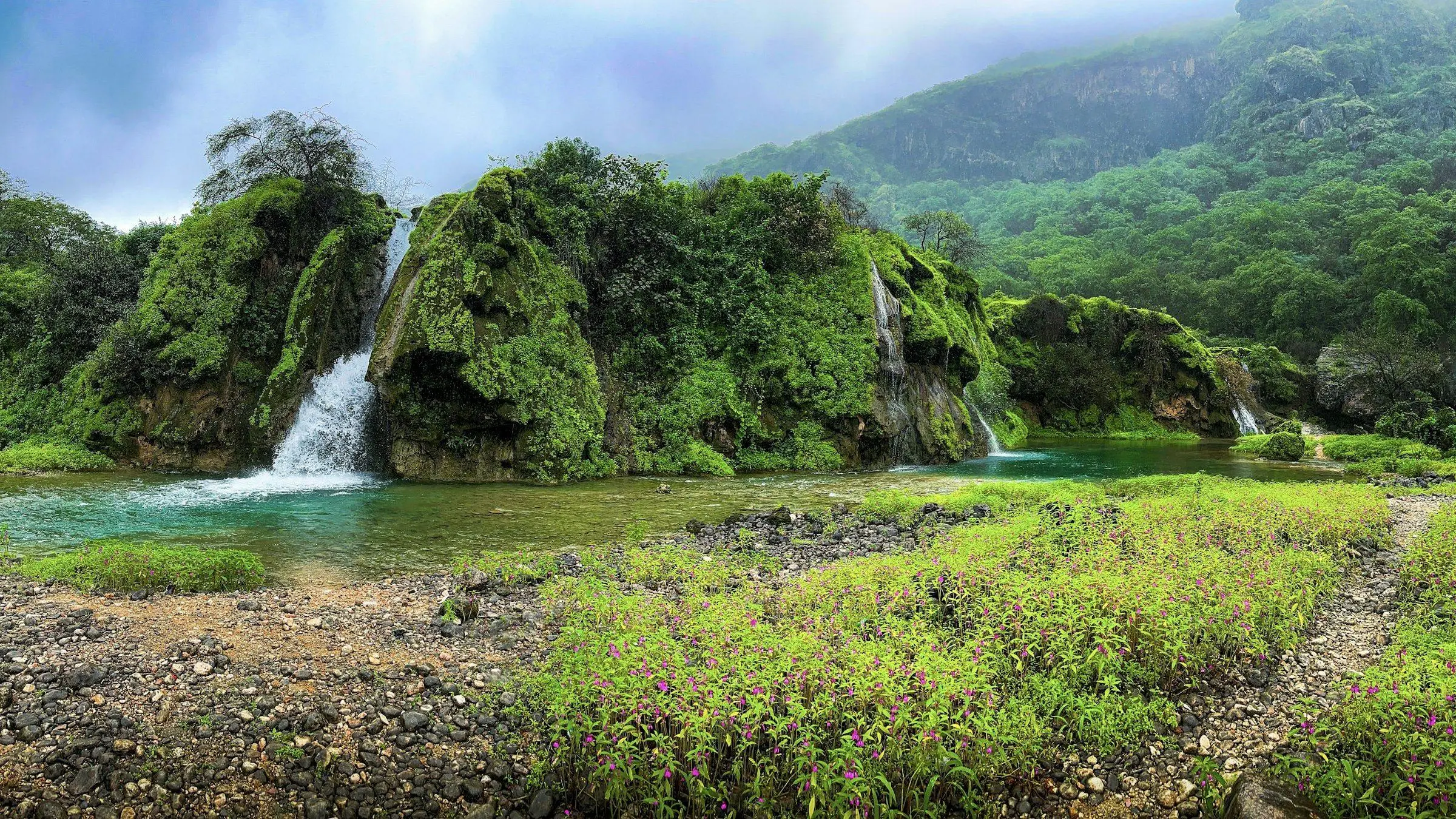 Waterfalls and green hills near Salalah in the khareef season, Dhofar, Oman