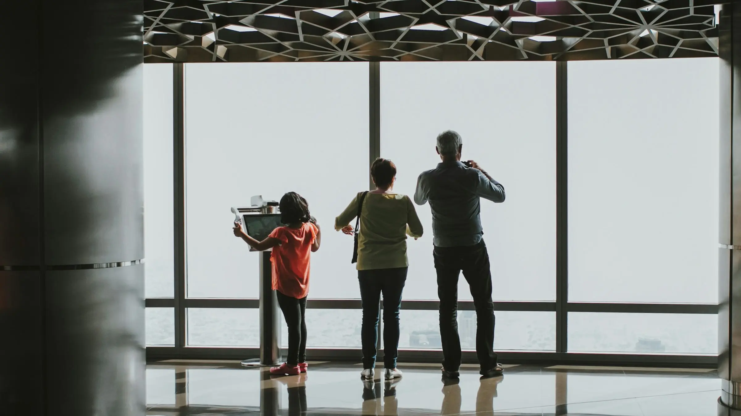 A family at the observation deck windows of the Burj Khalifa, Dubai