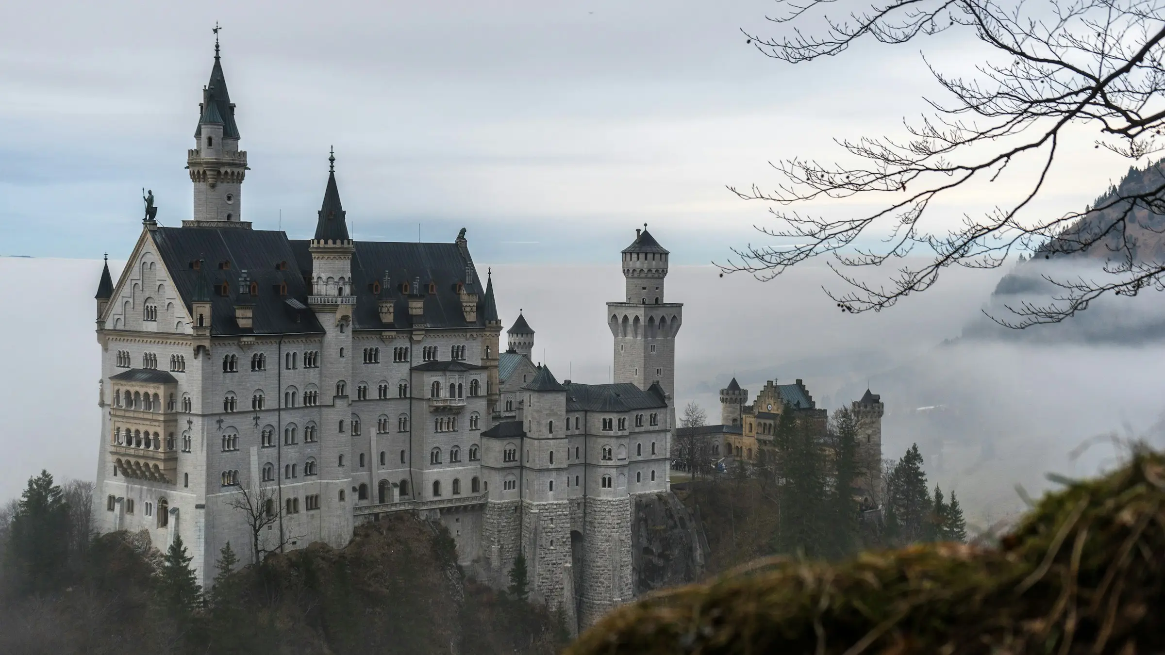 Neuschwanstein Castle above the Bavarian forest on a misty morning